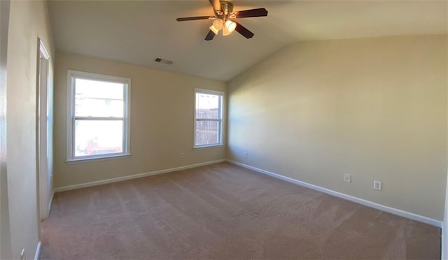 carpeted spare room featuring vaulted ceiling and ceiling fan