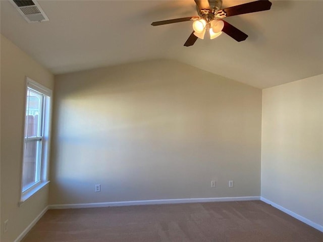 spare room featuring vaulted ceiling, ceiling fan, a healthy amount of sunlight, and carpet flooring