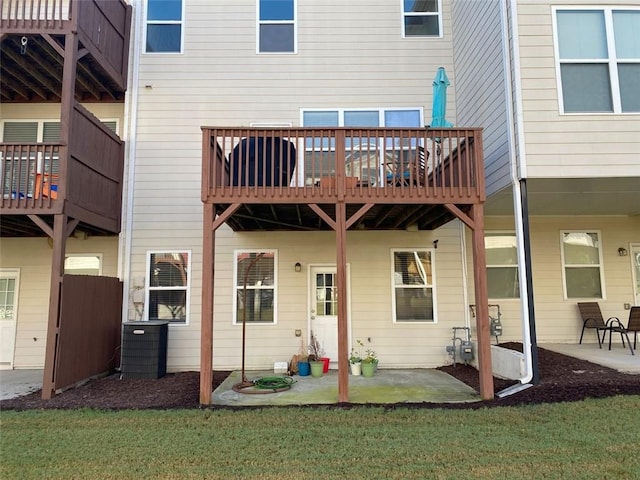 rear view of property featuring cooling unit, a patio area, and a lawn