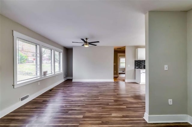 unfurnished living room featuring ceiling fan and dark wood-type flooring