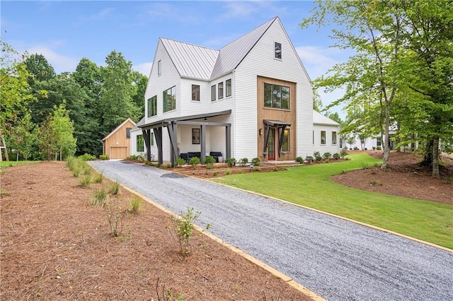 modern farmhouse style home with a front lawn, a standing seam roof, and metal roof