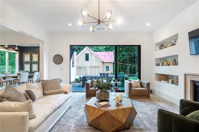 living area with visible vents, built in features, wood finished floors, recessed lighting, and a chandelier
