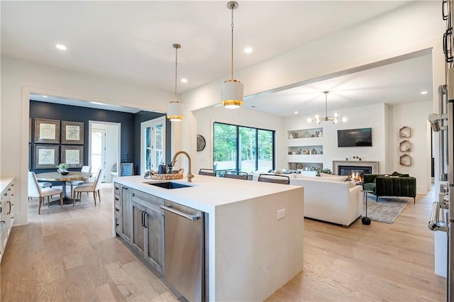 kitchen featuring stainless steel dishwasher, recessed lighting, a sink, and light wood-style floors