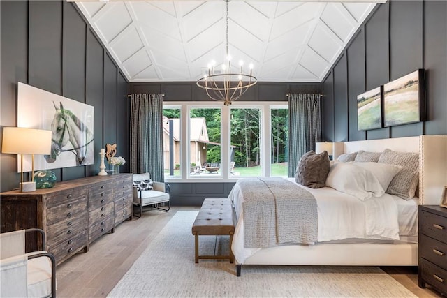 bedroom featuring light wood-type flooring, a decorative wall, and multiple windows