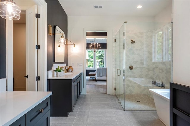 ensuite bathroom featuring tile patterned flooring, a stall shower, vanity, a notable chandelier, and ensuite bathroom