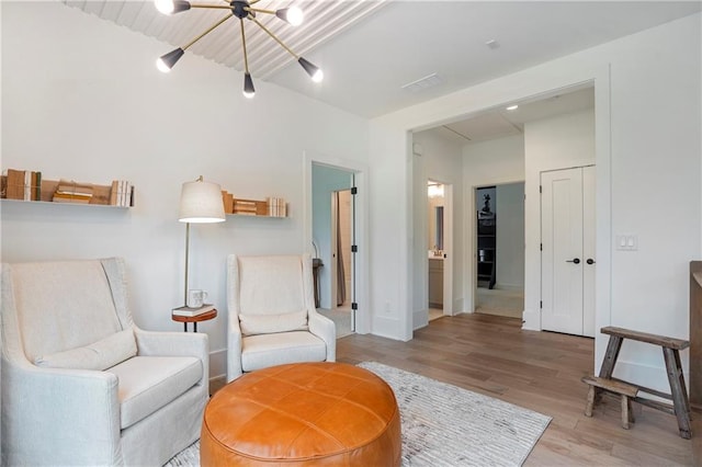 living area with a notable chandelier and light wood-style flooring