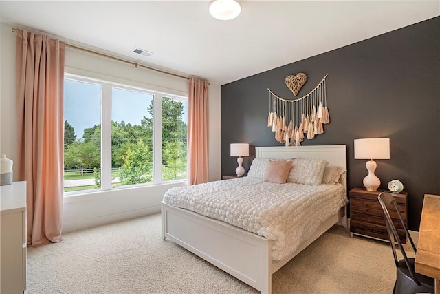 bedroom featuring visible vents and light carpet