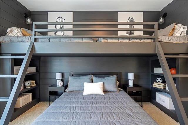 bedroom featuring wooden walls and carpet