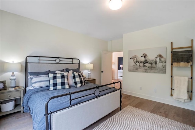bedroom with baseboards and wood finished floors