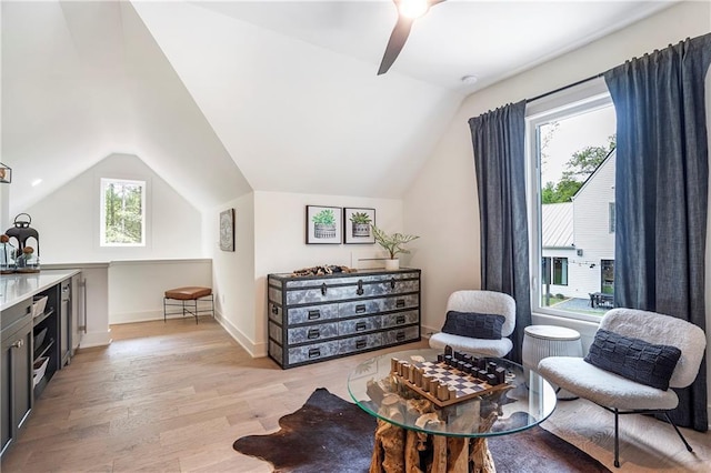 sitting room featuring baseboards, light wood finished floors, ceiling fan, and vaulted ceiling