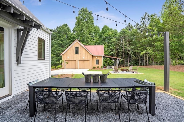 back of property with a lawn, an outdoor fire pit, metal roof, and a patio area