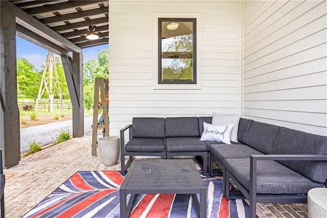 rear view of property with outdoor lounge area, a standing seam roof, a patio, a yard, and metal roof