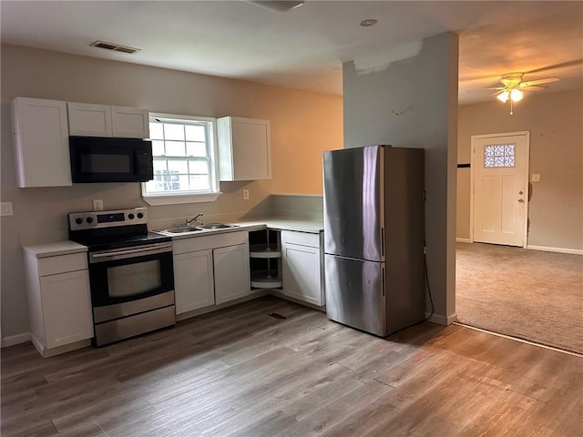 8 Hazel St, Porterdale, GA 30014 - kitchen with stainless steel appliances, a sink, light countertops, ceiling fan, and white cabinetry
