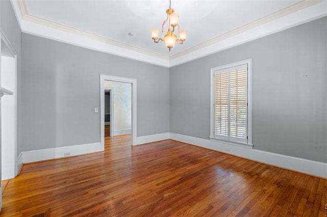 empty room with a chandelier, hardwood / wood-style floors, and crown molding