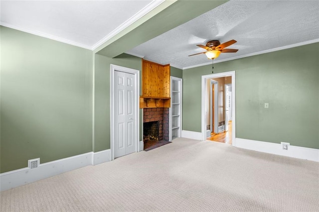 carpeted living room with ceiling fan, a textured ceiling, a fireplace, and ornamental molding