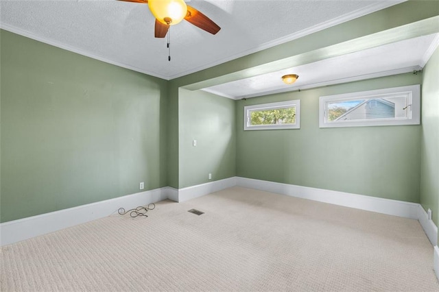 carpeted empty room with ceiling fan, a textured ceiling, and ornamental molding