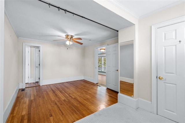 empty room with wood-type flooring, ornamental molding, and ceiling fan