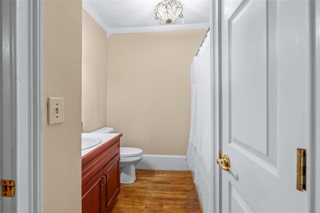 bathroom featuring hardwood / wood-style floors, a chandelier, vanity, and toilet