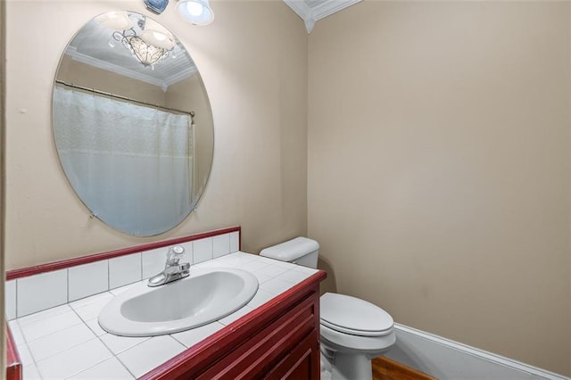 bathroom with ornamental molding, vanity, and toilet