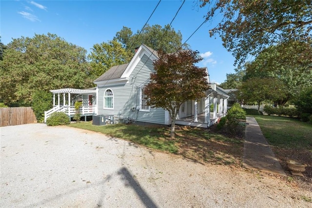 view of side of home with central AC unit and a pergola