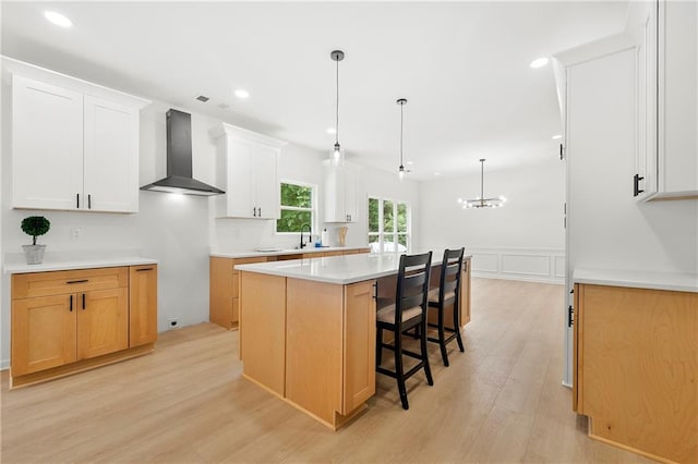 3684 Clearbrooke Way, Duluth, GA 30097 - kitchen featuring wall chimney exhaust hood, a kitchen island, a sink, light wood finished floors, and wainscoting