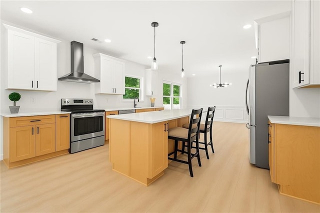 3684 Clearbrooke Way, Duluth, GA 30097 - kitchen featuring wall chimney exhaust hood, appliances with stainless steel finishes, light wood-style flooring, a kitchen island, and light countertops