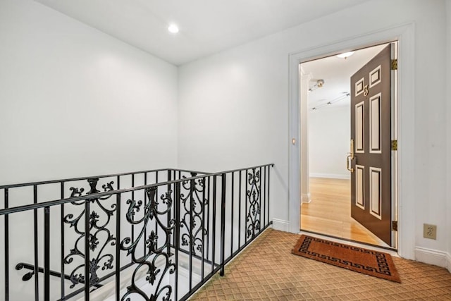 corridor with baseboards, wood finished floors, and recessed lighting