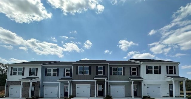 townhome / multi-family property with board and batten siding and a garage