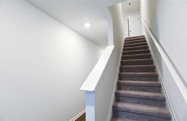 stairs with baseboards and recessed lighting