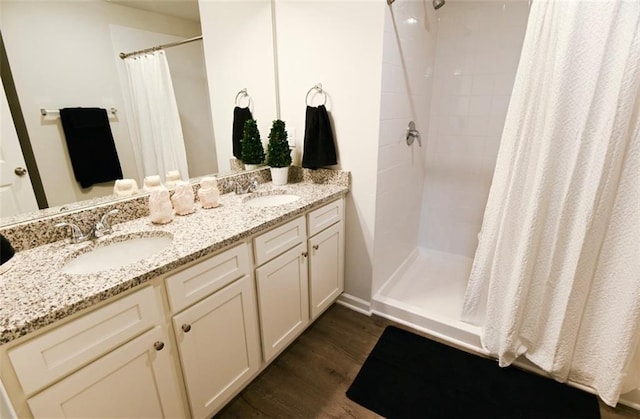 bathroom featuring a sink, a tile shower, and wood finished floors