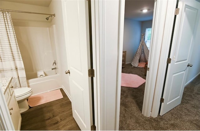 bathroom with vanity, wood finished floors, shower / bath combination with curtain, and toilet