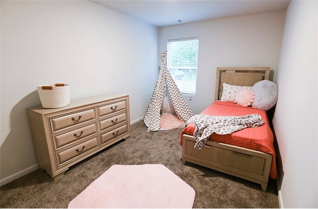 bedroom with baseboards and dark colored carpet