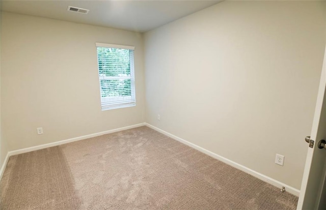 carpeted empty room featuring visible vents and baseboards