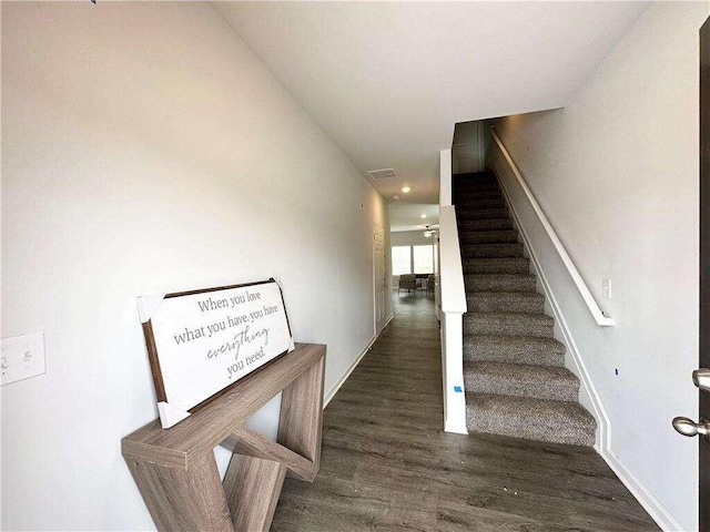 stairs with wood finished floors and visible vents