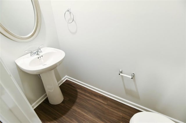 bathroom featuring toilet, baseboards, and wood finished floors