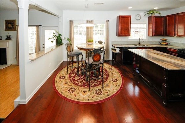 3554 Umatilla Ln SW, South Fulton, GA 30331 - kitchen with dark brown cabinets, black dishwasher, a sink, dark wood finished floors, and recessed lighting
