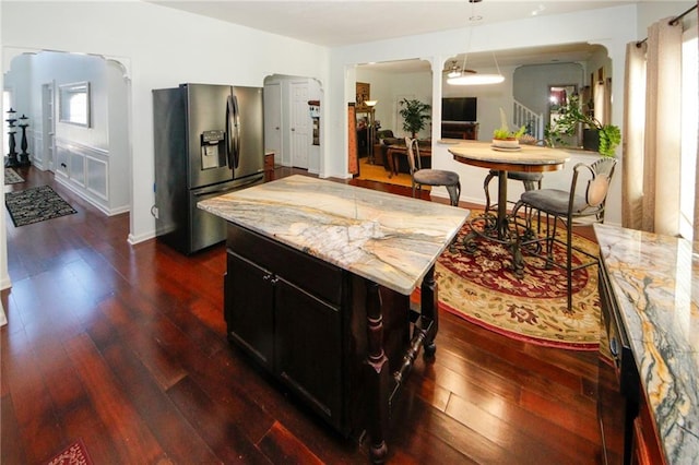 3554 Umatilla Ln SW, South Fulton, GA 30331 - kitchen with stainless steel fridge, dark wood finished floors, hanging light fixtures, and light stone counters