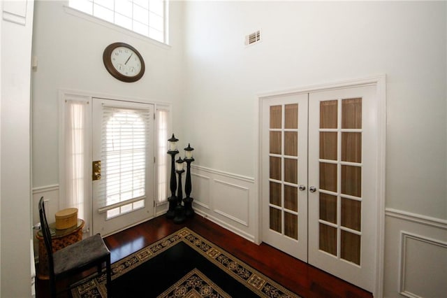 3554 Umatilla Ln SW, South Fulton, GA 30331 - entryway with french doors, dark wood finished floors, wainscoting, a decorative wall, and a high ceiling