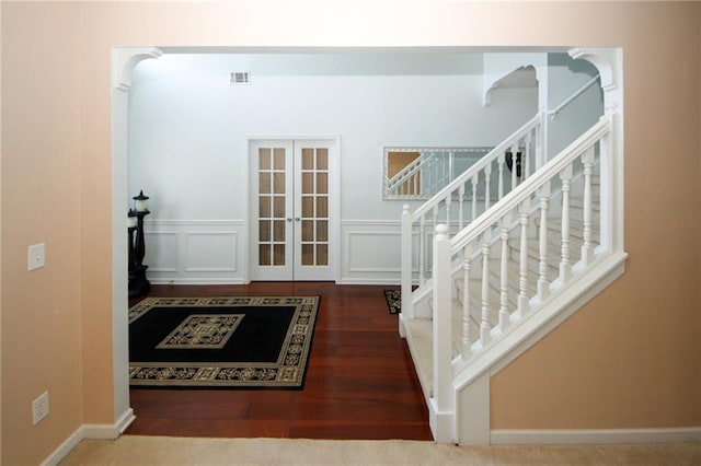 3554 Umatilla Ln SW, South Fulton, GA 30331 - foyer entrance featuring french doors, stairway, wood finished floors, a wainscoted wall, and a decorative wall