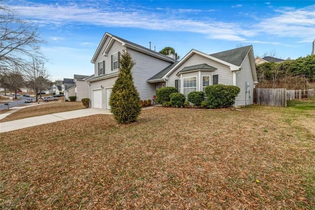 view of front of home with a garage, driveway, a front lawn, and fence