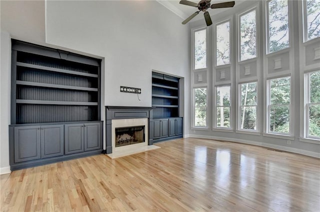 1723 Woodbow Path, Dacula, GA 30019 - unfurnished living room with healthy amount of natural light, a fireplace, built in shelves, a ceiling fan, and a high ceiling