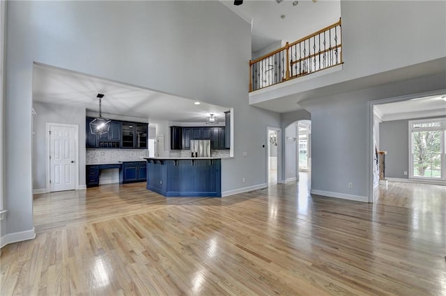 1723 Woodbow Path, Dacula, GA 30019 - unfurnished living room with a towering ceiling, light wood finished floors, and arched walkways