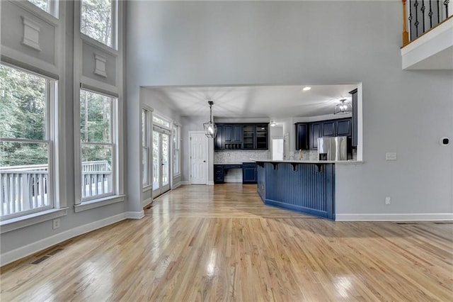 1723 Woodbow Path, Dacula, GA 30019 - unfurnished living room featuring a towering ceiling, light wood-type flooring, a chandelier, and recessed lighting