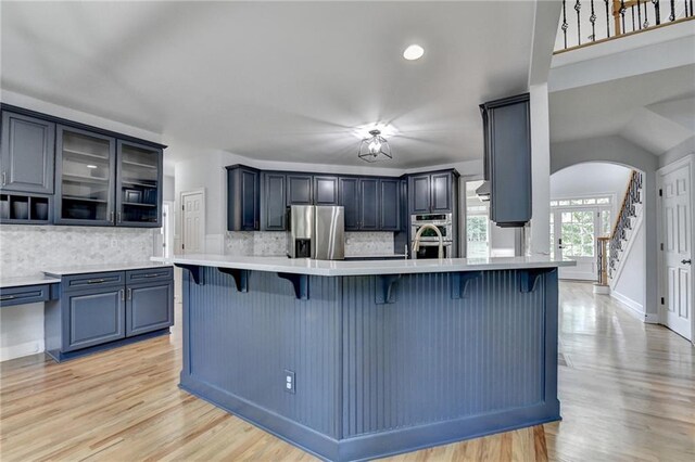 1723 Woodbow Path, Dacula, GA 30019 - kitchen with stainless steel appliances, a kitchen breakfast bar, arched walkways, light wood-style flooring, and recessed lighting