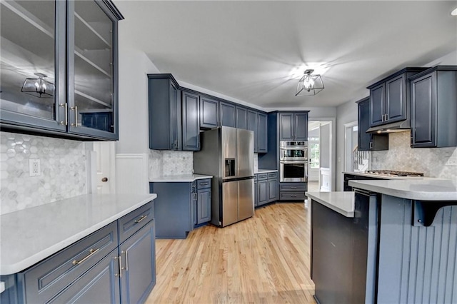 1723 Woodbow Path, Dacula, GA 30019 - kitchen with stainless steel appliances, backsplash, light wood-style flooring, and a peninsula