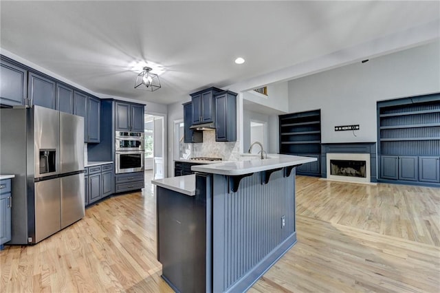 1723 Woodbow Path, Dacula, GA 30019 - kitchen with appliances with stainless steel finishes, light wood-style floors, a peninsula, a breakfast bar, and recessed lighting