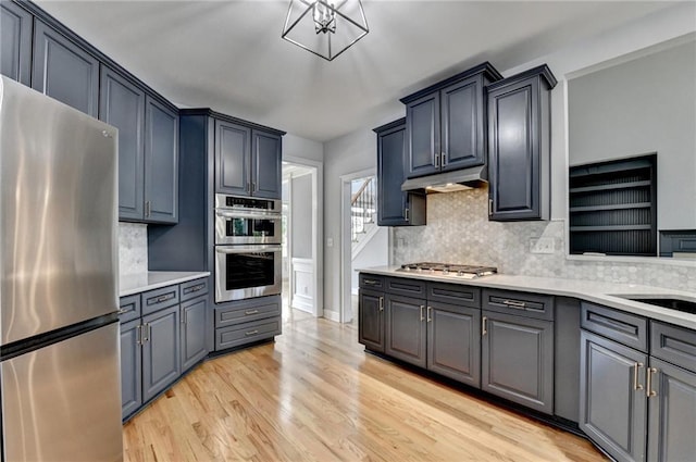 1723 Woodbow Path, Dacula, GA 30019 - kitchen with appliances with stainless steel finishes, light wood-type flooring, backsplash, and light countertops