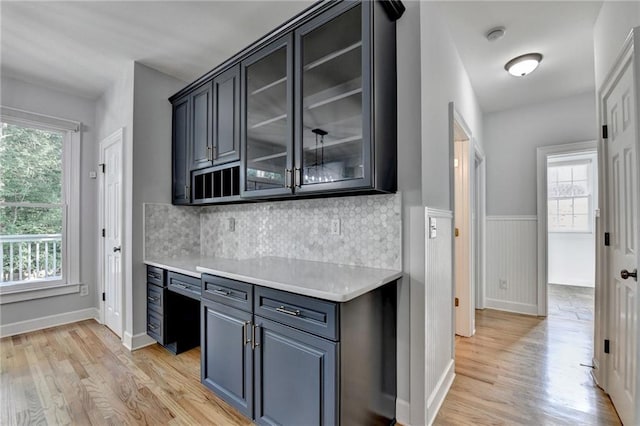1723 Woodbow Path, Dacula, GA 30019 - kitchen featuring light wood-style flooring, plenty of natural light, light countertops, glass insert cabinets, and a wainscoted wall