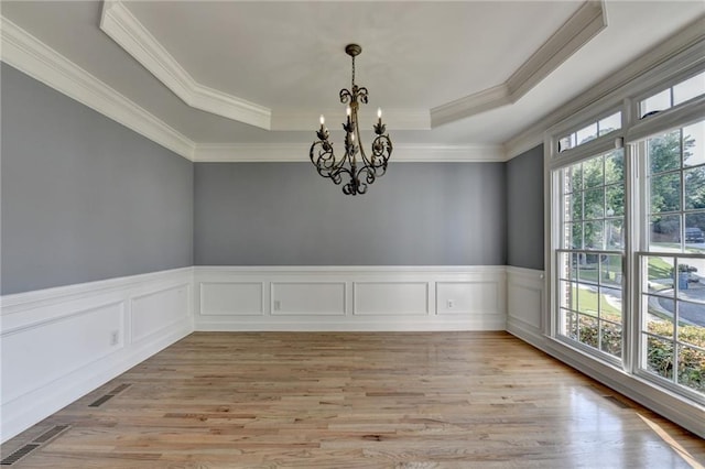 1723 Woodbow Path, Dacula, GA 30019 - unfurnished room with healthy amount of natural light, a raised ceiling, a chandelier, light wood-type flooring, and crown molding
