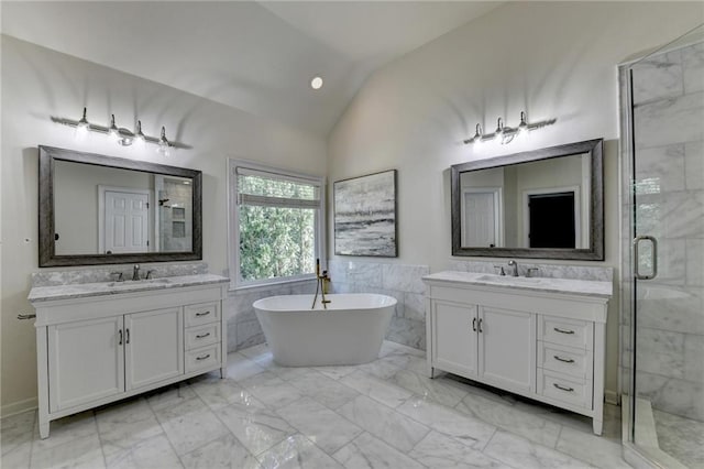 1723 Woodbow Path, Dacula, GA 30019 - bathroom featuring marble finish floors, a shower stall, two vanities, vaulted ceiling, and tile walls